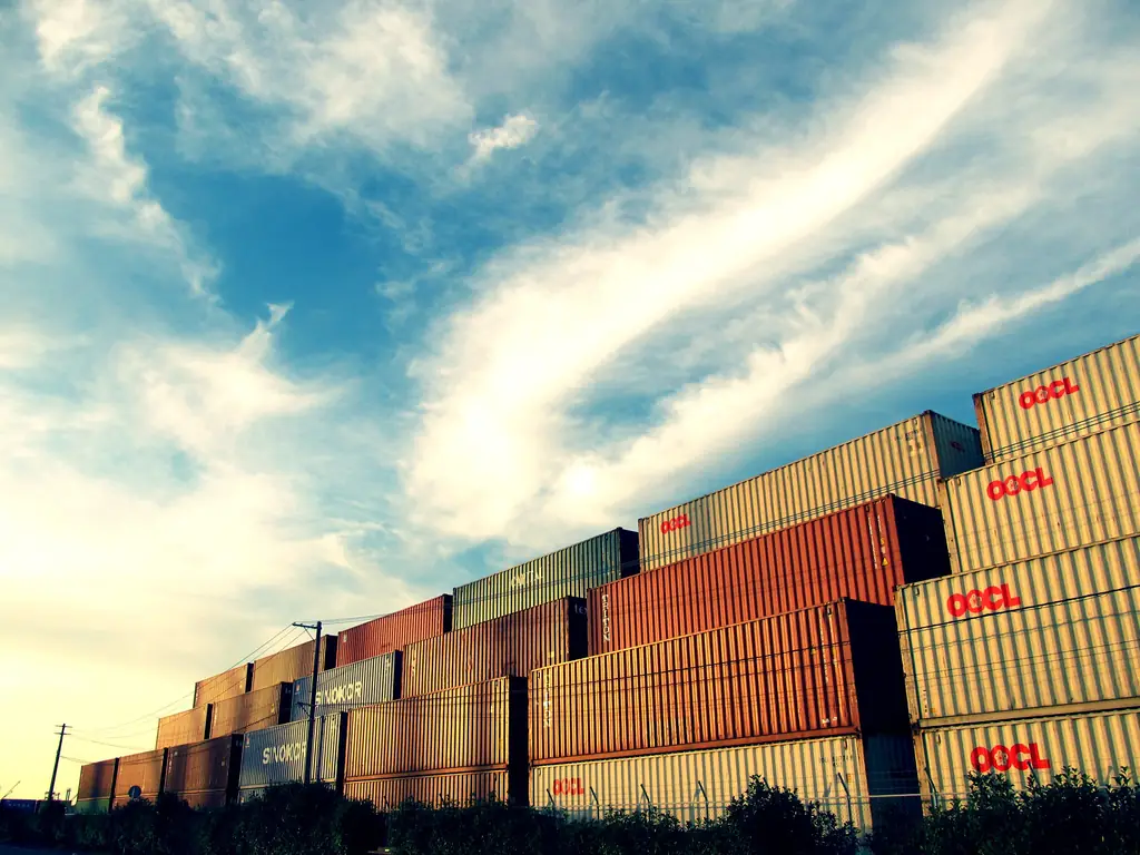 Shipping containers stacked several high under a dramatic sky